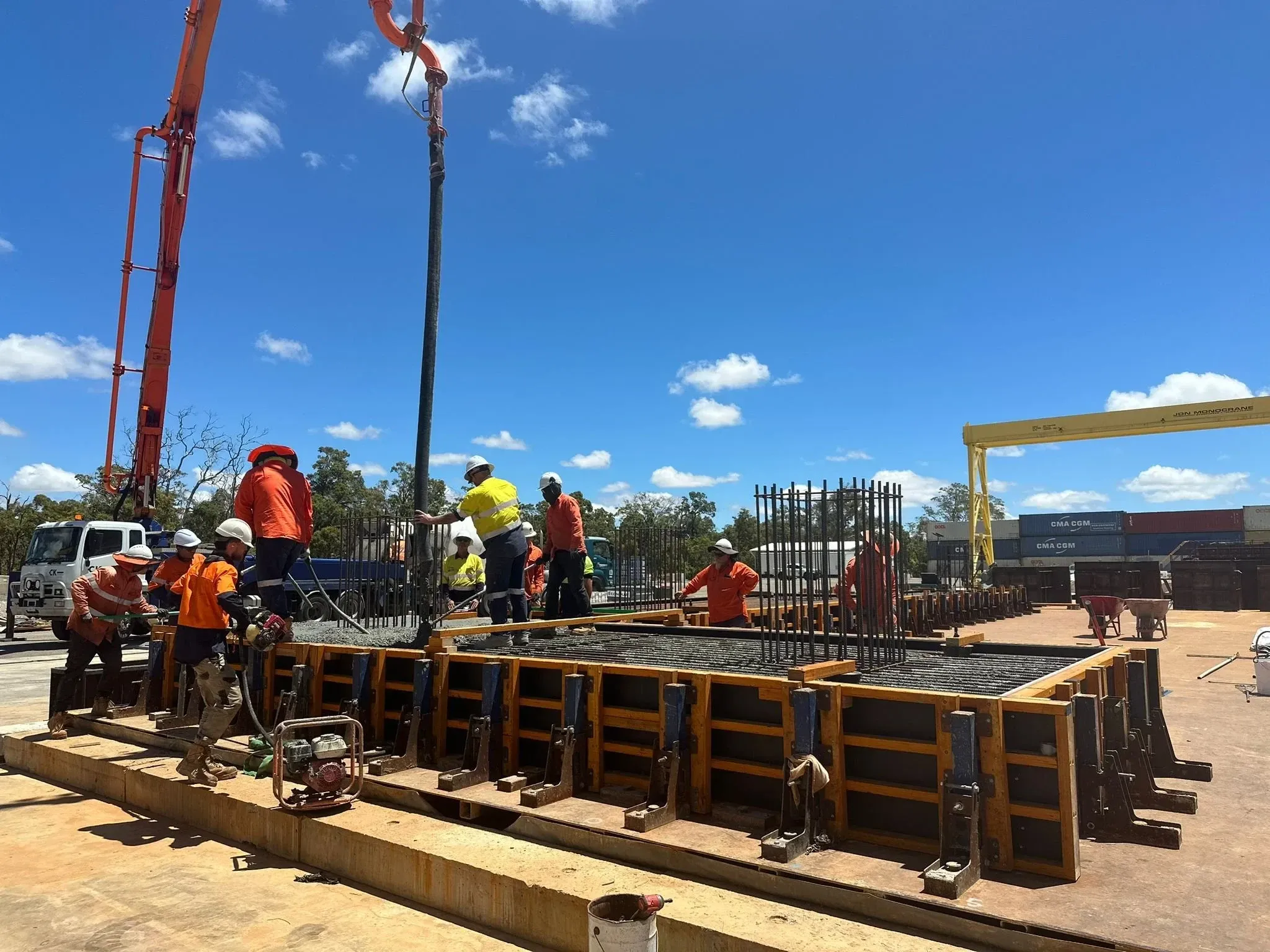 Crew placing concrete from a pump boom into slab formwork