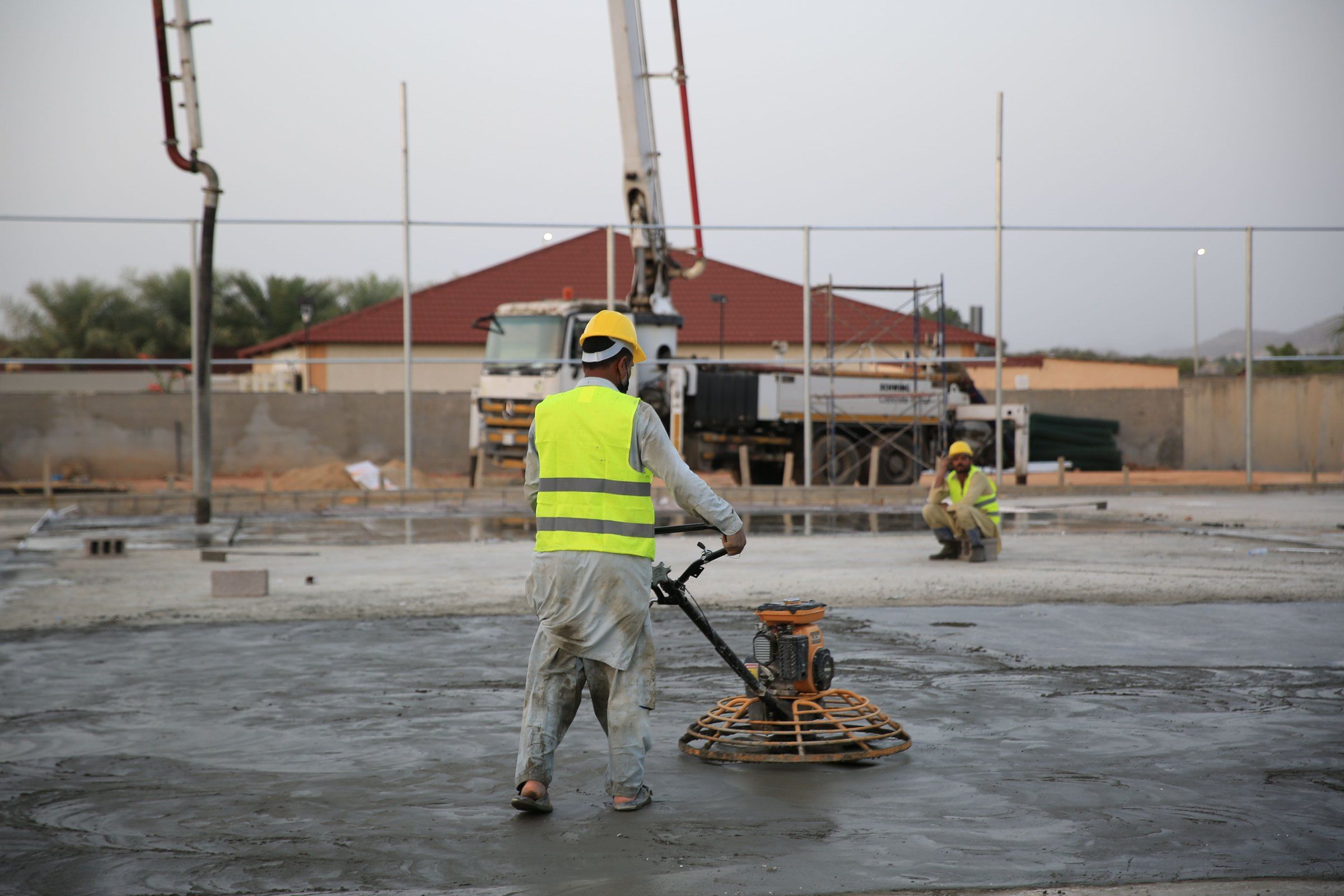 Worker power-floating a large concrete slab