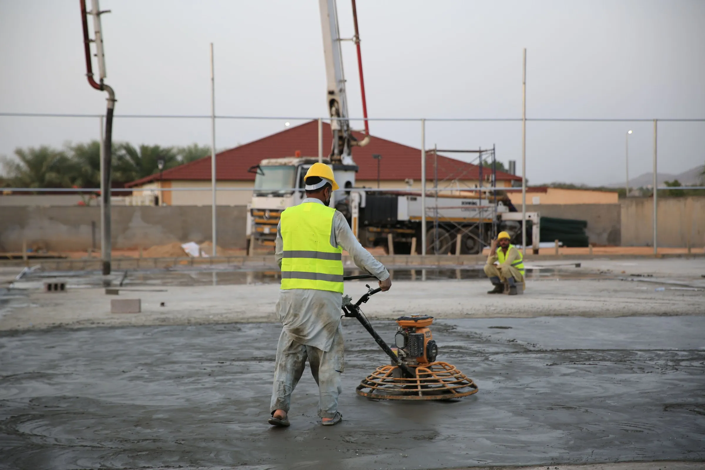 Worker power-floating a large concrete slab
