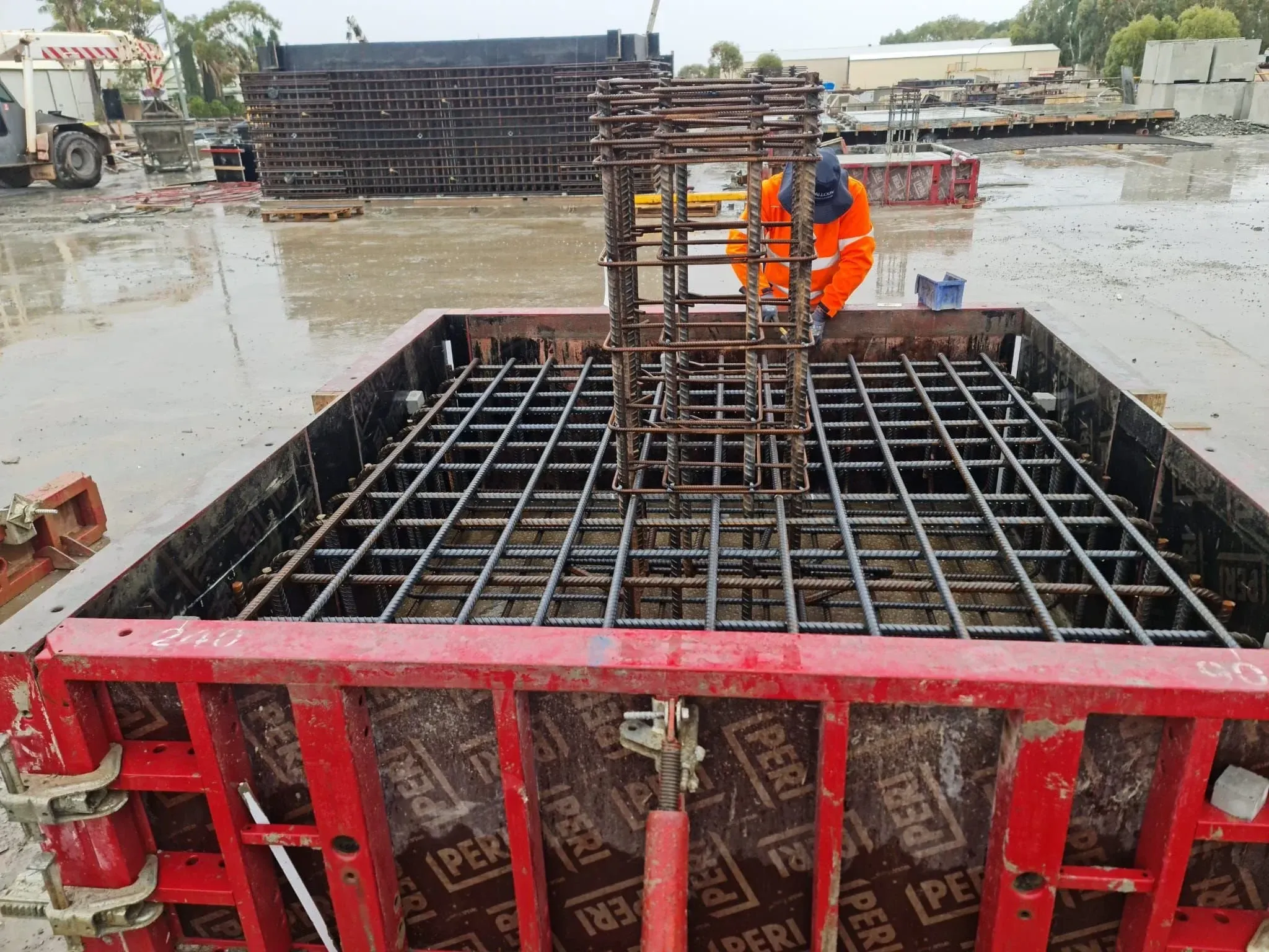 Steel fixer tying a reinforcement cage inside slab formwork