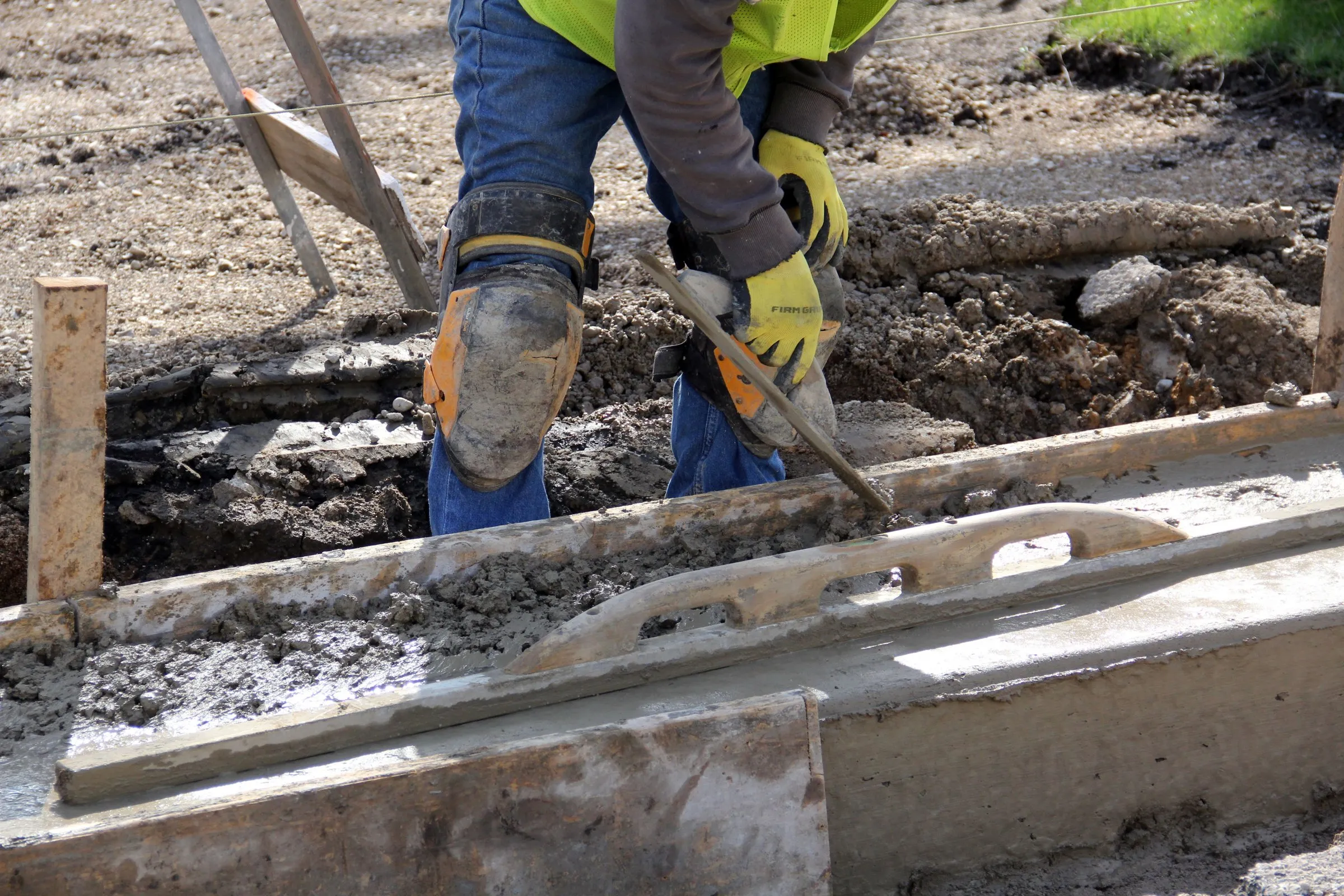 Concrete finisher smoothing a slab edge with a trowel
